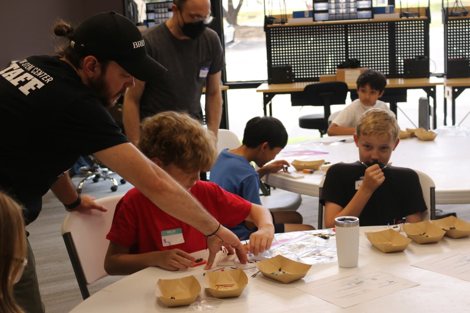 ASC staff helping campers sort components at the build table