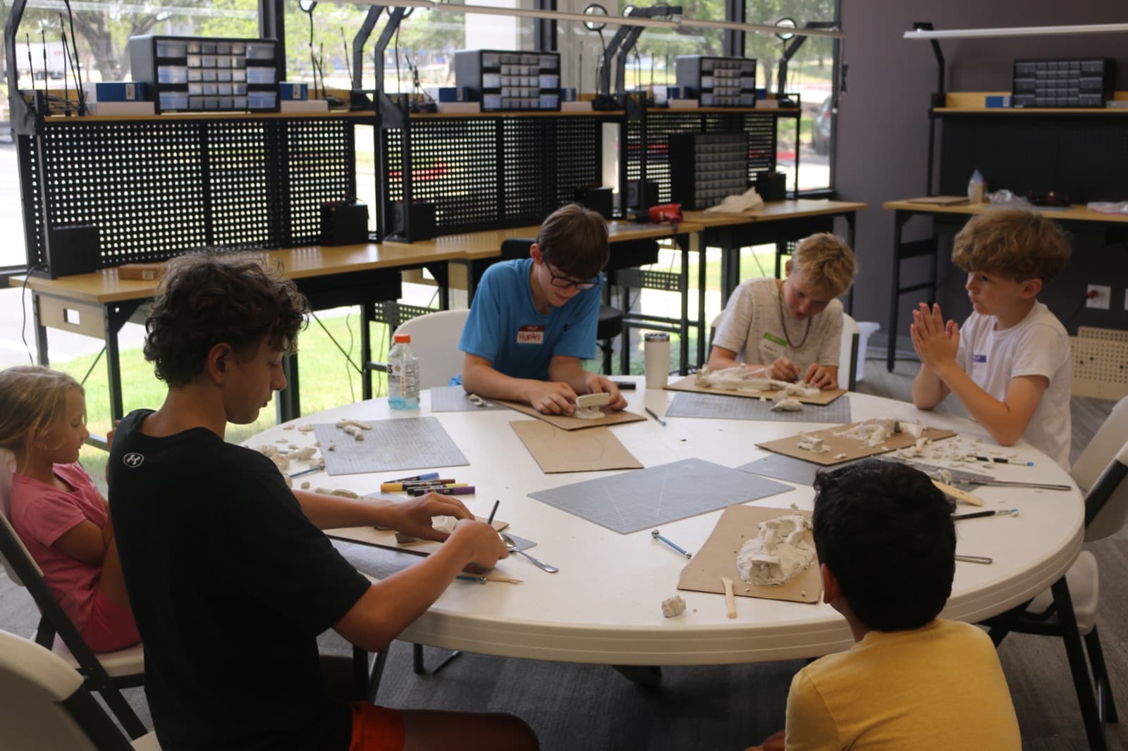 Campers building and tuning car parts around the round table