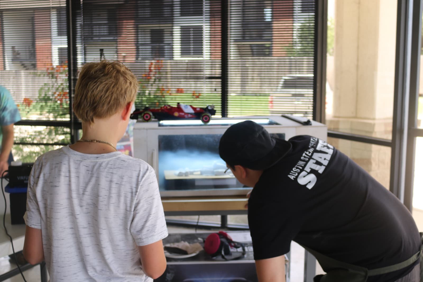 Campers watching a run at the track with a model race car up top